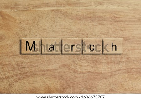 March word written on wood block. Message text on wooden table for backdrop design.