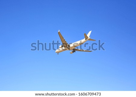 Commercial jet airplane flight on blue sky background. Seen from below.