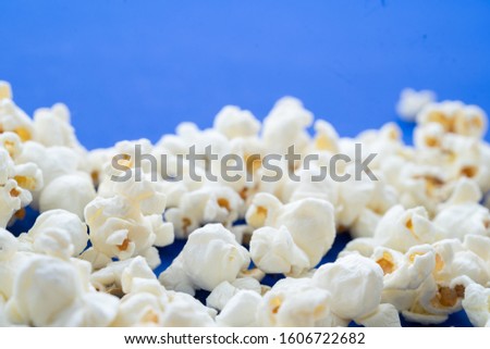 Close up salty white popcorn on classic blue background.