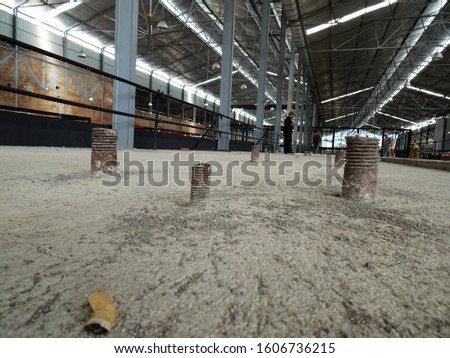 Unused and embedded bolts in old factory concrete floor 