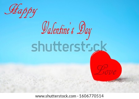 Red heart with the text "Love" on white sand beach and ''Happy Valentine's Day'' over blue sky background used for your design, for lover romantic symbol. Holiday, summer and valentine's day concept.
