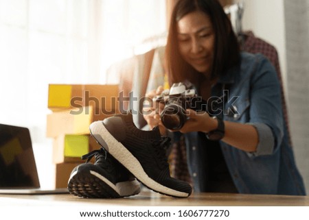 Women business owner taking photo to shoes with digital camera, for post to selling online on the internet