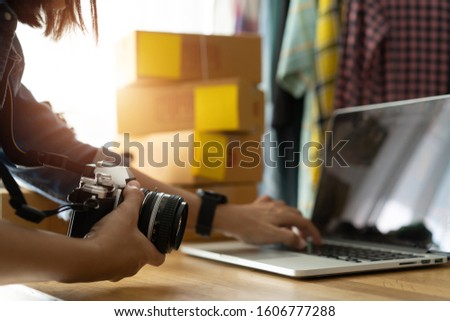 Women business owner working laptop computer selling online, With hold the camera