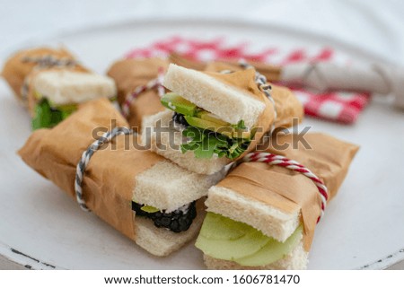 Close-up of two sandwiches with bacon, salami, prosciutto and fresh vegetables