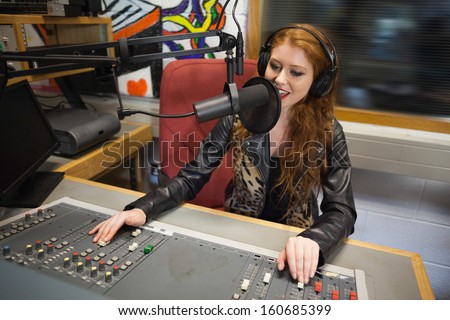 Happy beautiful radio host moderating sitting in studio at college