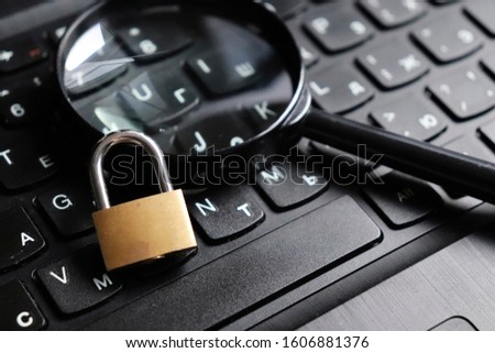 Lock with magnifying glass on the computer keyboard. The concept of security of search engines. Search and protect your computer from viruses and cyber attacks.