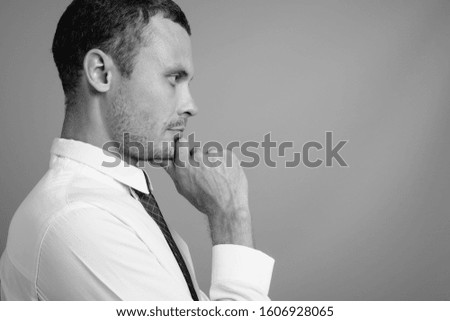 Portrait of handsome businessman against gray background