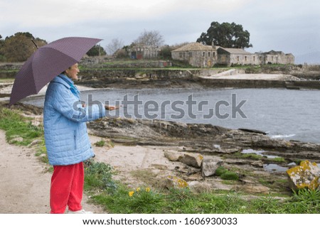 senior woman with umbrella in autumn