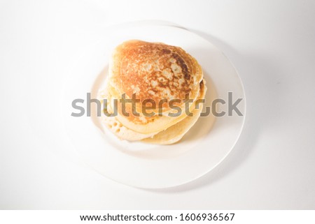 pancakes are stacked on a white plate. On a white background
