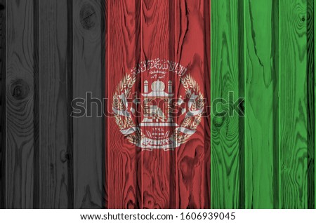 Afghanistan flag depicted in bright paint colors on old wooden wall. Textured banner on rough background