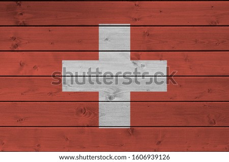 Switzerland flag depicted in bright paint colors on old wooden wall. Textured banner on rough background