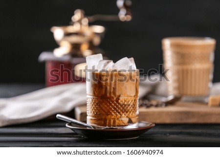 Glass of tasty cold coffee on dark table