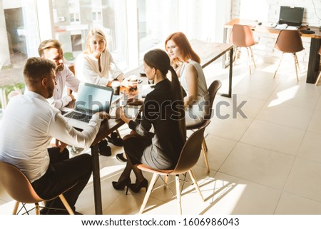 A team of young businessmen working and communicating together in an office. Corporate businessteam and manager in a meeting. Royalty-Free Stock Photo #1606986043