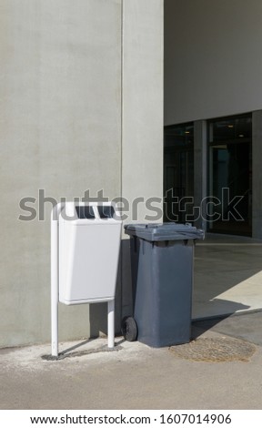 White and black garbage trash bins at the entrance of a sports hall