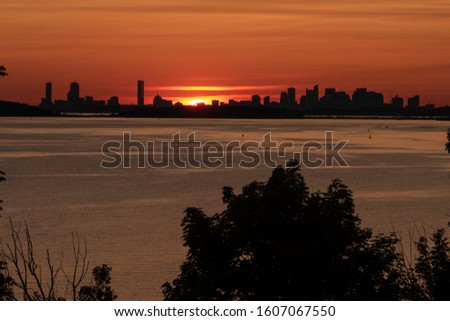Boston Skyline Silhouette against setting sun under fiery sky