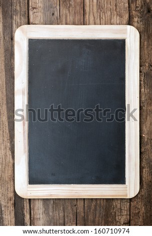 Vintage chalkboard hanging on old wooden background