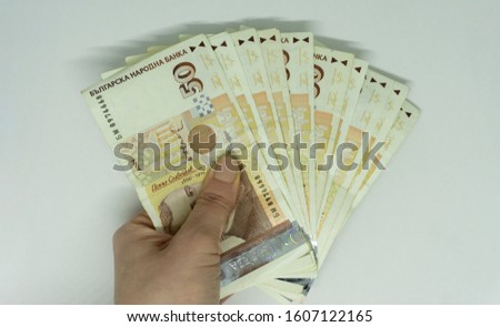 Woman hand holding pile of Bulgarian lev banknotes (BGN) - 50 levs. Option for illustrating subjects as business, incoming, banking, personal finances, trade, taxes, media, presentations, etc.