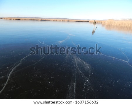 The shiny ice of the frozen Lake Velence in Hungary on a sunny winter day, pure nature without people