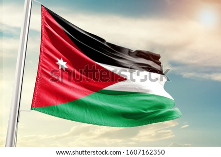 Jordan national flag cloth fabric waving on the sky with beautiful sun light