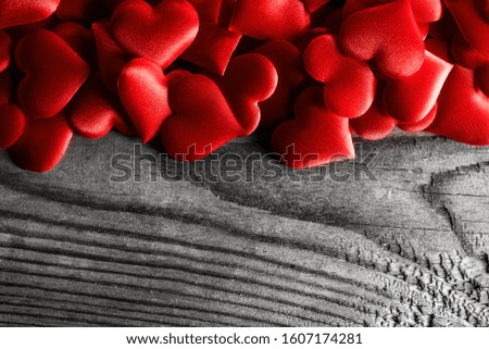 Valentine's day many red silk hearts on wooden background, love concept