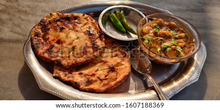 Spicy chick peas curry or Chola or Chana Masala or Chole Kulche garnished with green chili or coriander leaf . A popular dish in most of the people in North of India. Amritsari kulcha with chola.