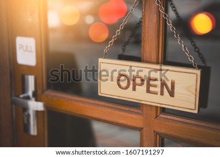Open sign broad hanging on wood door front of cafe. Business service and food concept. Vintage tone filter effect color style.