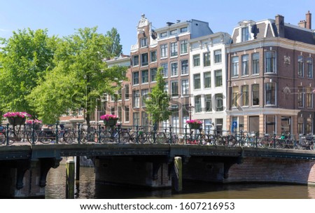 Beautiful view of Amsterdam canals with bridge and typical dutch houses, the Netherlands.