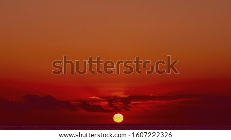 Down over the sea in spindrift clouds. Red sunset or sunrise in ocean