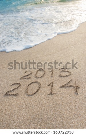New Year 2014 season is coming concept - inscription 2013 and 2014 on a beach sand Royalty-Free Stock Photo #160722938