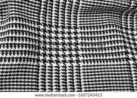 Winter cashmere scarf. Black and white cage texture fabric. Textile warm dark knitted cloth background.