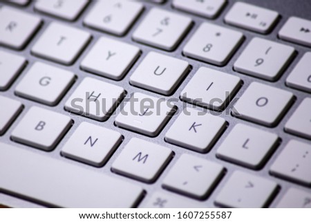 A close up of a computer keyboard - no drastic post production. Sharp detailed macro photography of a modern aluminium keyboard with white keys and grey letters and silver background 