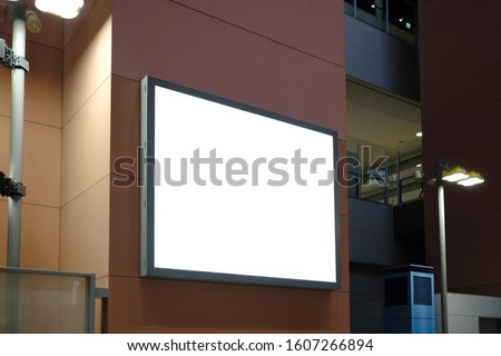 Blank white mockup of bus stop vertical billboard in front of empty street background.