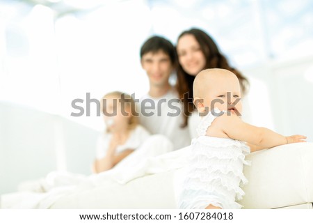 happy little baby on blurred background of the famil