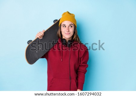 young skater caucasian woman isolated dreaming of achieving goals and purposes