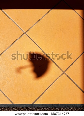 umbrella shadow on yellow tile floor