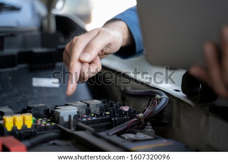 Close up hands of unrecognizable mechanic doing car service and maintenance.