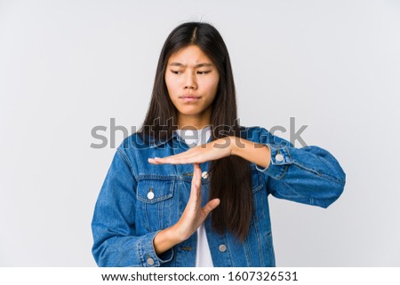 Young asian woman showing a timeout gesture.