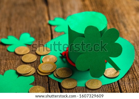 Happy Saint Patrick's mockup of handmade felt hat shamrock clover leaves and confetti on wooden table
