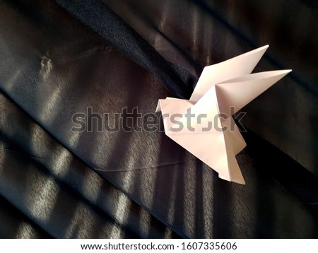 White Japanese origami paper birds on a black cloth background