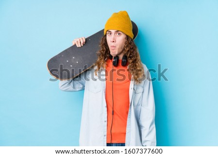 Young caucasian skater man isolated shrugs shoulders and open eyes confused.