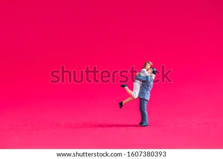 miniature couple isolated on pink  background.