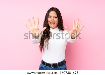 Young woman over isolated pink background counting ten with fingers