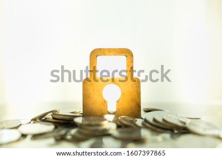 Money and Security Concept. Close up of wooden master key lock icon on pile of coins with copy space.