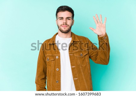 Young handsome man smiling cheerful showing number five with fingers.