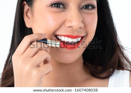 Close up face of beauty Asian woman is applying red lipstick and makeup. Concept of cosmetic and skin care