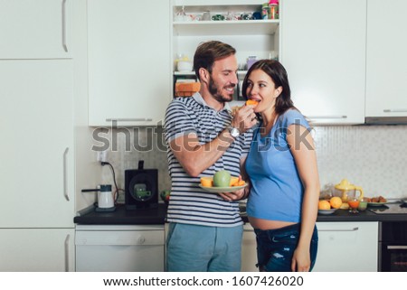 Pregnant woman with husband in the kitchen
