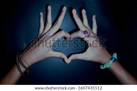  Female hands making sign Heart by fingers, isolated on blue black  background. Beautiful hands of woman with copy space. Love concept on Valentine day stock photos images