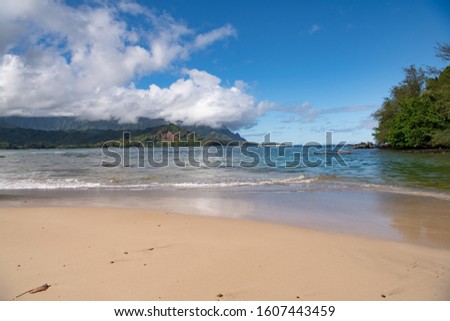 view of the beautiful Hanalei beach on Kauai Island, Hawaii with the tranquil turquoise pacific Ocean gently lapping the sands 