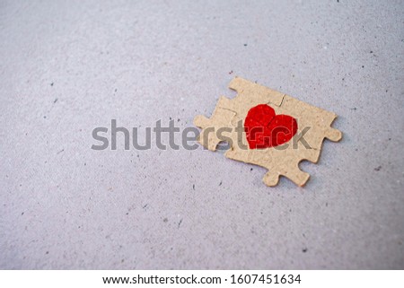 A picture of a paper puzzle with a red heart