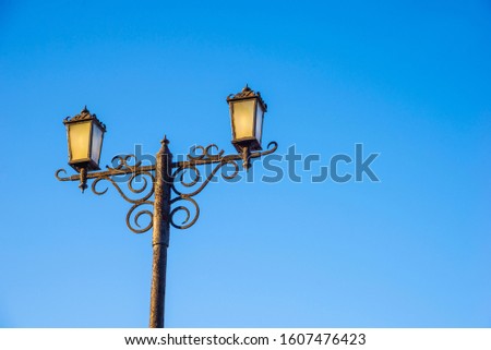Two street lights against the blue sky. Urban architecture.